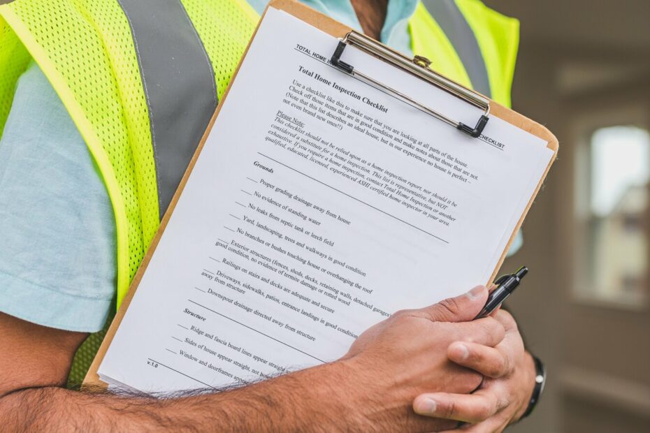 Diagnostiqueur immobilier verifiant un rapport sur une checklist de controle